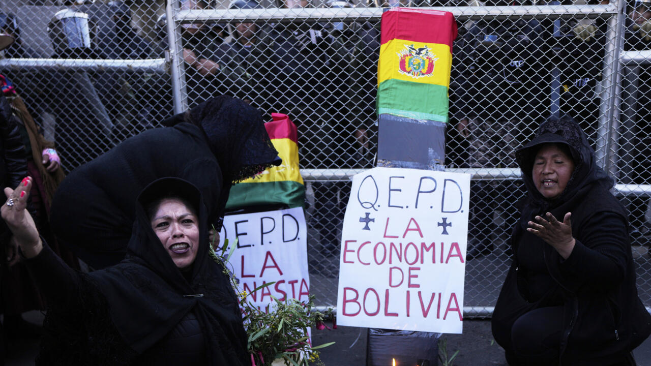 Simpatizantes del expresidente Evo Morales gritan consignas junto a una caja que se asemeja a un ataúd con un cartel que dice en español: "Descanse en paz, la economía de Bolivia" mientras exigen que se le permita a Morales postularse nuevamente a la presidencia en las próximas elecciones cerca del palacio de gobierno en La Paz, Bolivia, el miércoles 4 de junio de 2025.